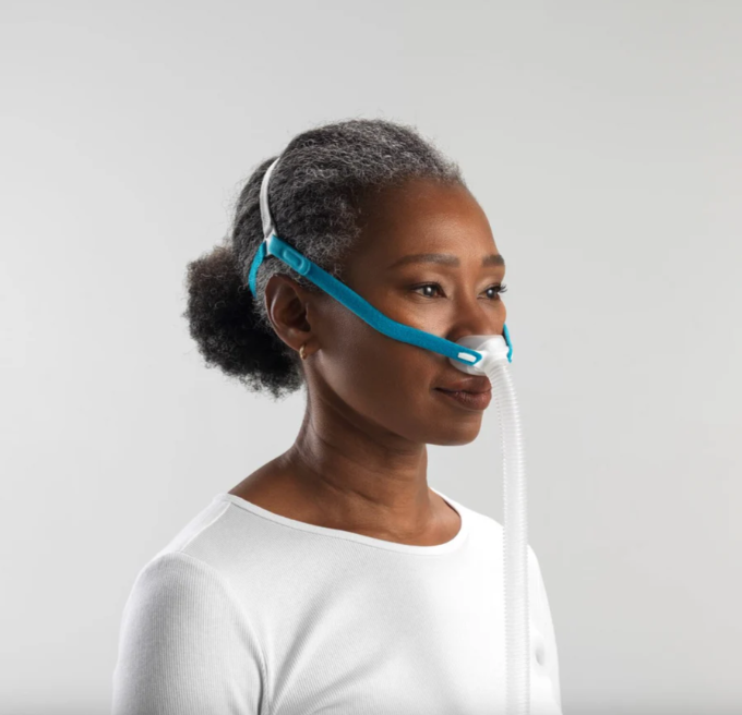 Woman wearing F&P Nova Micro lightweight CPAP mask, demonstrating minimal-contact fit