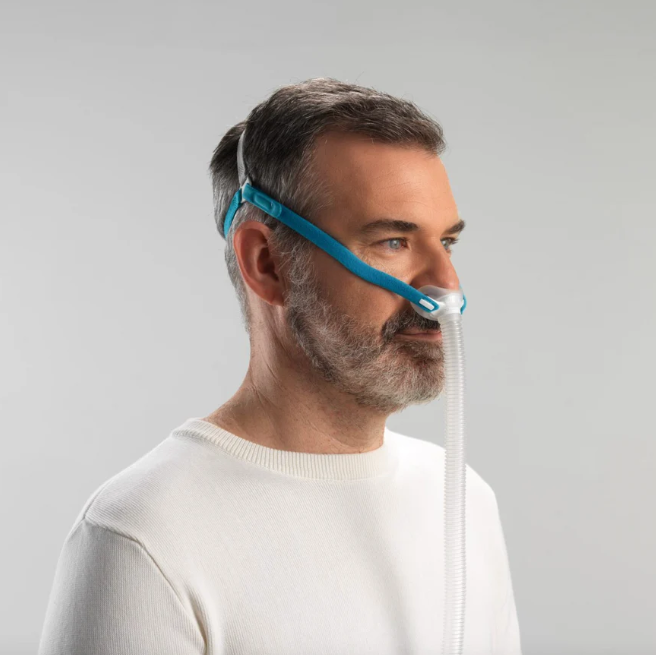 Man using Fisher & Paykel Nova Micro mask connected to CPAP hose during sleep therapy