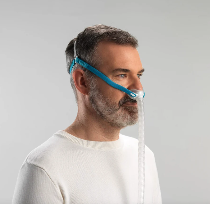 Man using Fisher & Paykel Nova Micro mask connected to CPAP hose during sleep therapy
