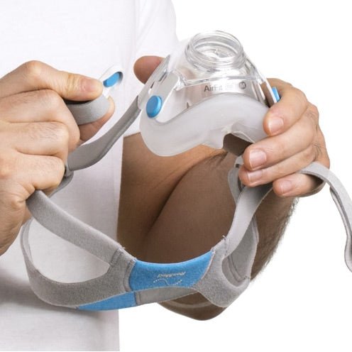 a man touching an airfit f20 cpap mask